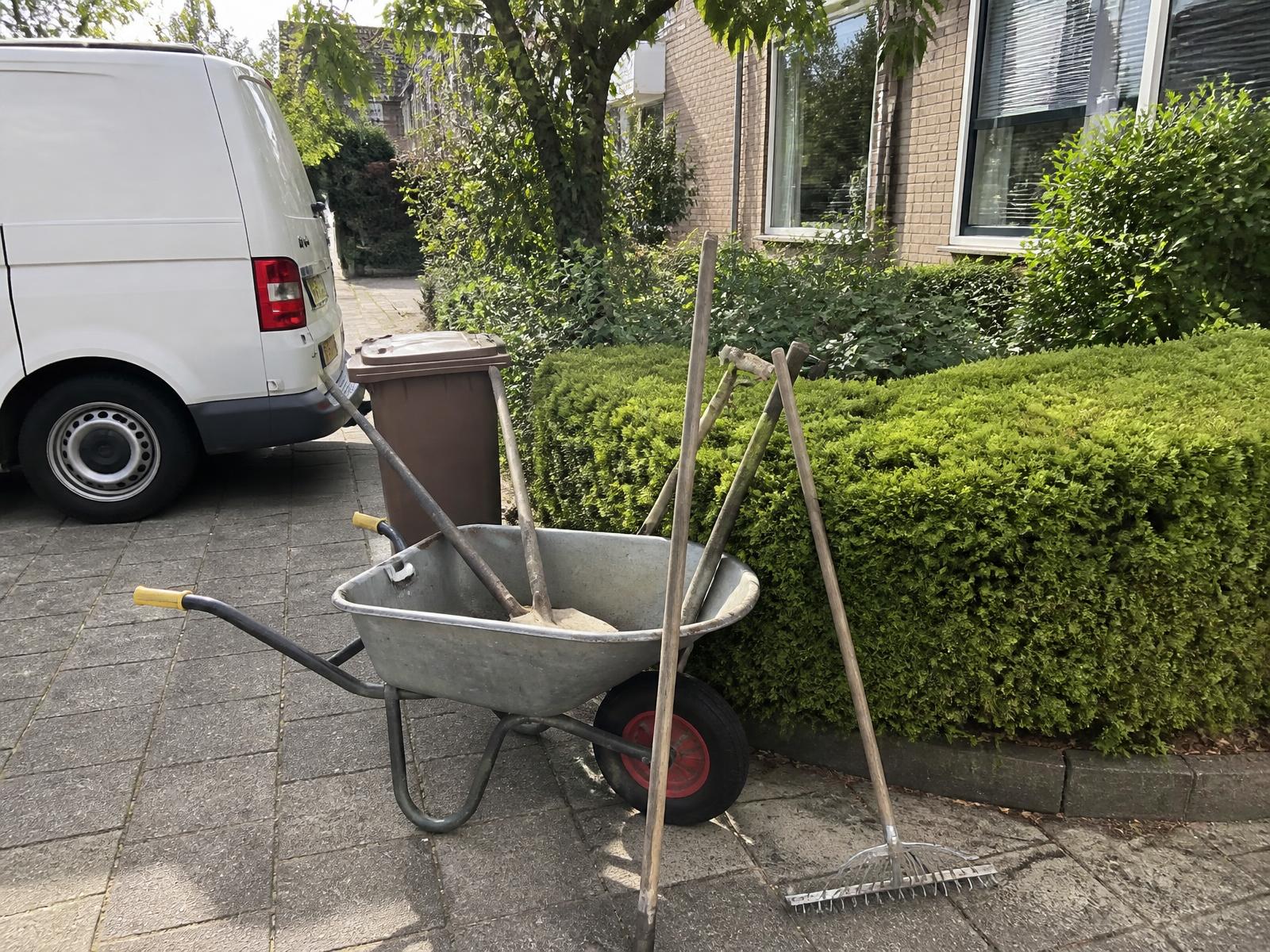 Gereedschap en bedrijfsbus van JP Buitenbeheer bij een verzorgde voortuin